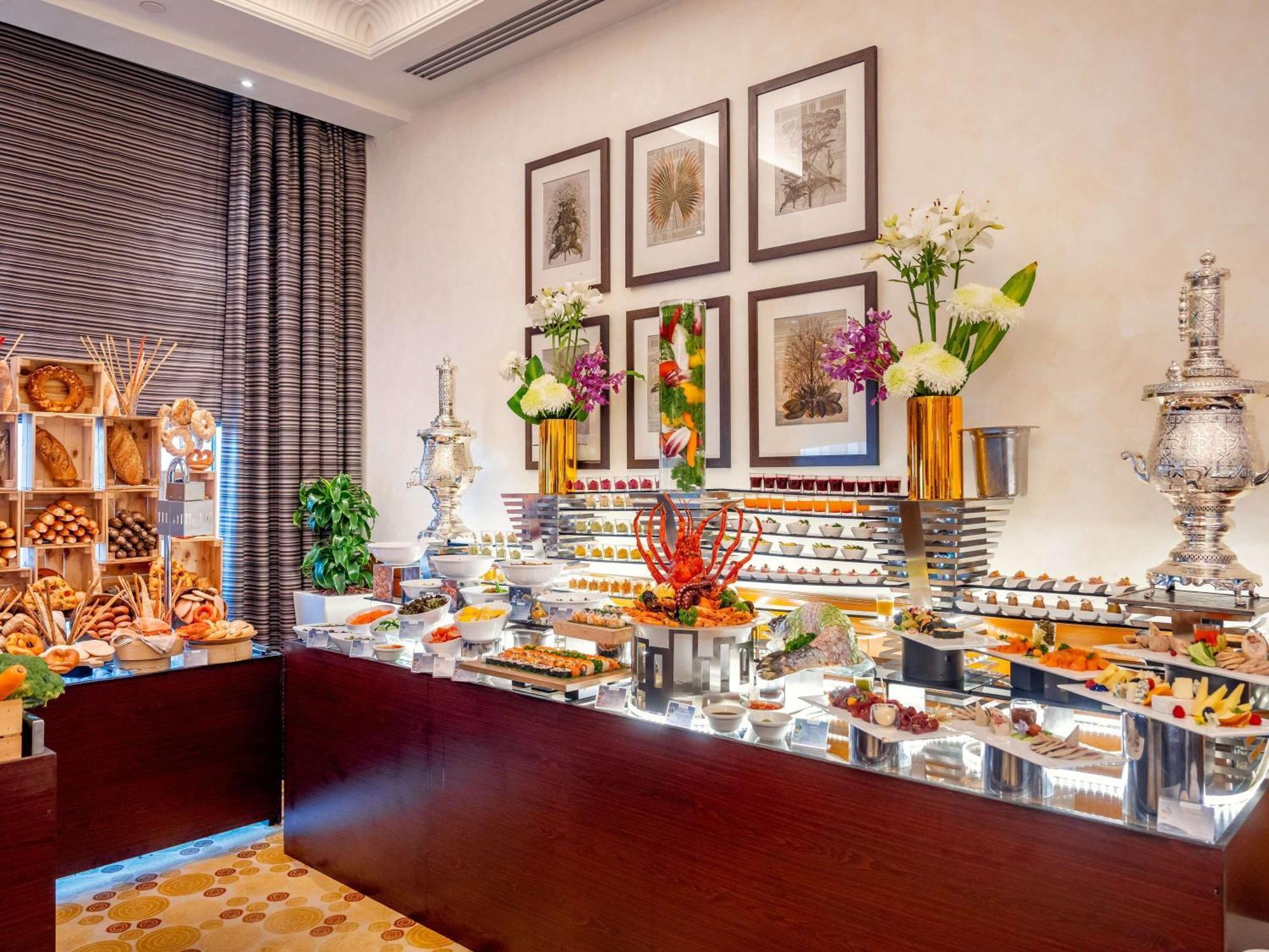 Swissotel Al Maqam Makkah Mekka Buitenkant foto The image depicts an elegantly arranged buffet display, featuring a variety of culinary offerings. There are multiple tiers of food items, including colorful fruits, desserts, and savory dishes. The presentation includes decorative elements such as f